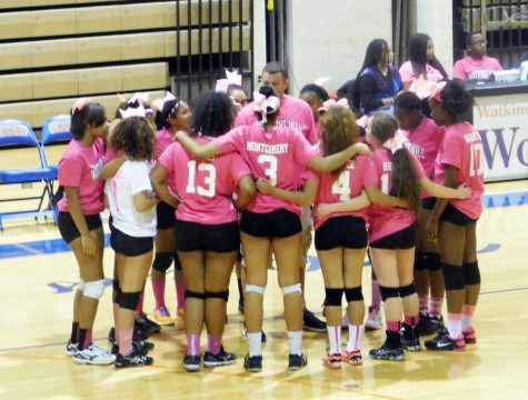 The team huddles up for their Dig Pink senior night