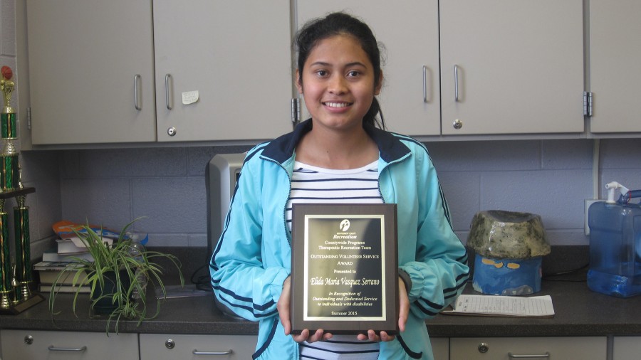 La estudiante de último año Elida Maria Vasquez Serrano con su placa de Voluntaria del Año