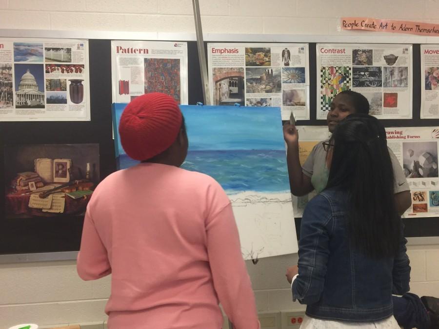 The members of the art club working on their painting .