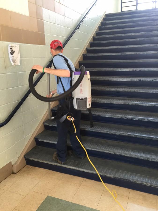 Trabajador de servicios de construcción Cliff Kerr limpiando las escaleras