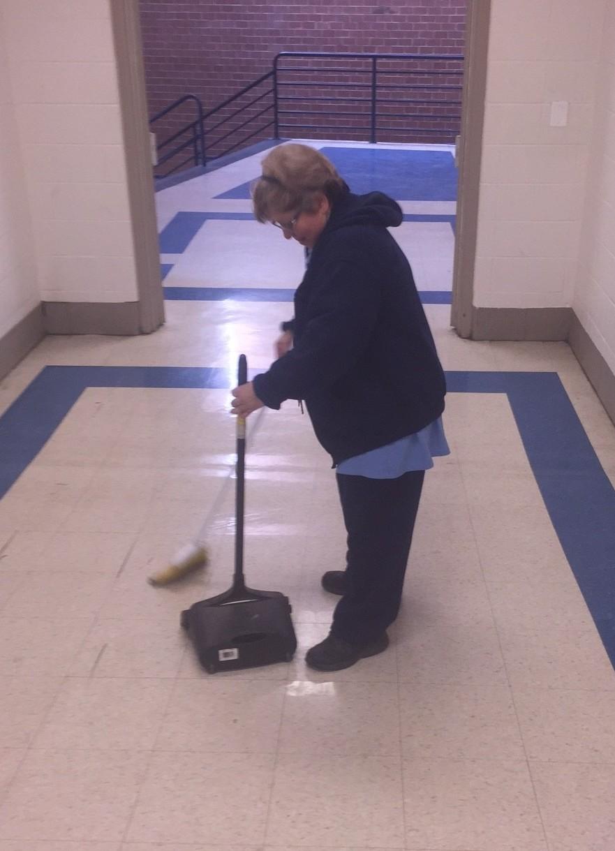 Building services worker Elsa Bastilas sweeps the hallway.