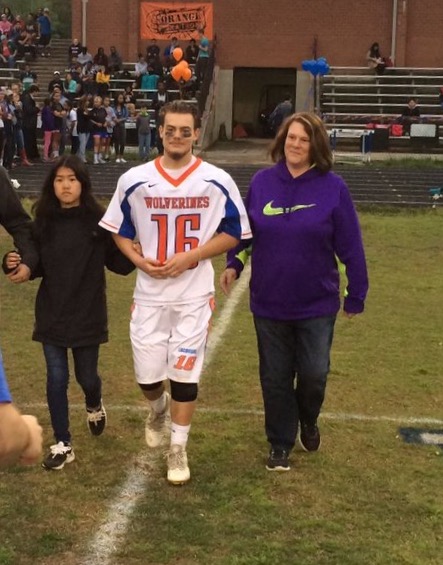 Senior Michael Spalding is escorted across the field for his senior night on the lacrosse team.