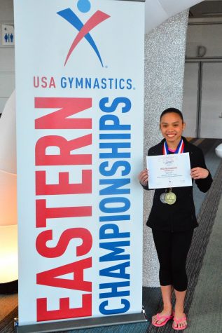 Freshman Nathalie Adriano poses with her winning certificate from the gymnastics Eastern Championships