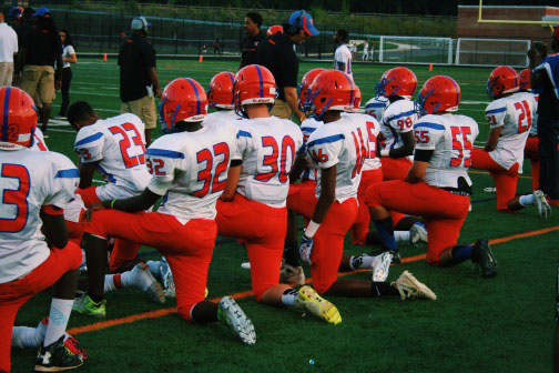 Football, girls soccer teams protest injustice by kneeling during National Anthem