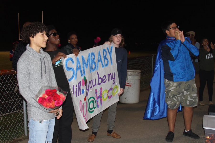 (De izquierda a derecha): el joven Sergio García con flores y amigos, Hezekiah Likekele y Alex Wright tienen un cartel durante el partido de fútbol vs Seneca Valley