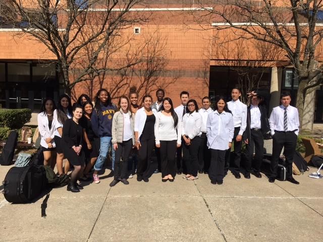 The orchestra poses after festival at Quince Orchard High School