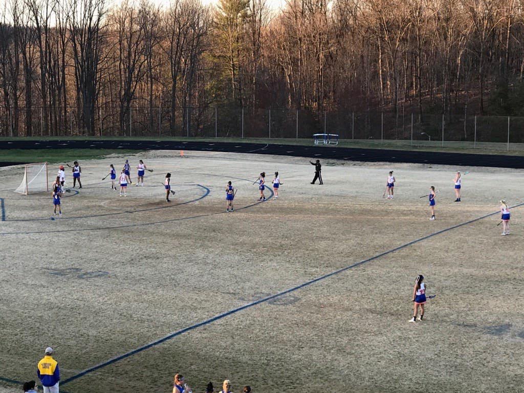 Girls+lacrosse+in+the+middle+of+their+game.+