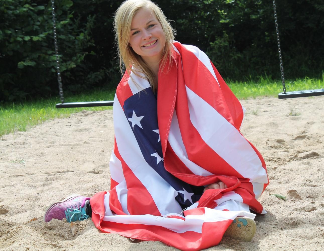 Alemán de intercambio de estudiantes Louisa Boockhoff posando con una bandera estadounidense.