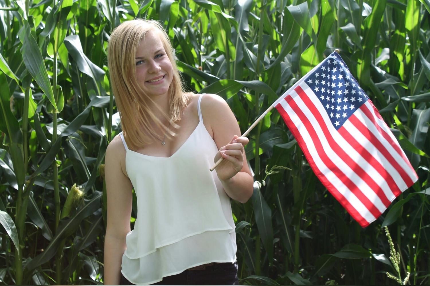 Estudiante de segundo año + Louisa + Boockhoff + posando + con + un + Americano + Bandera. +