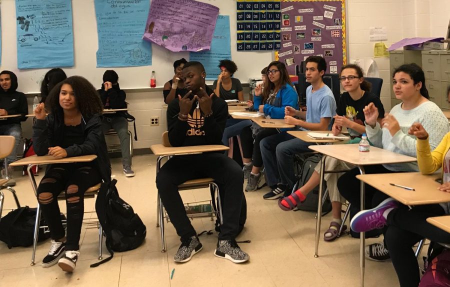 Los estudiantes de la clase de lenguaje de signos americano practican sus nuevas habilidades.