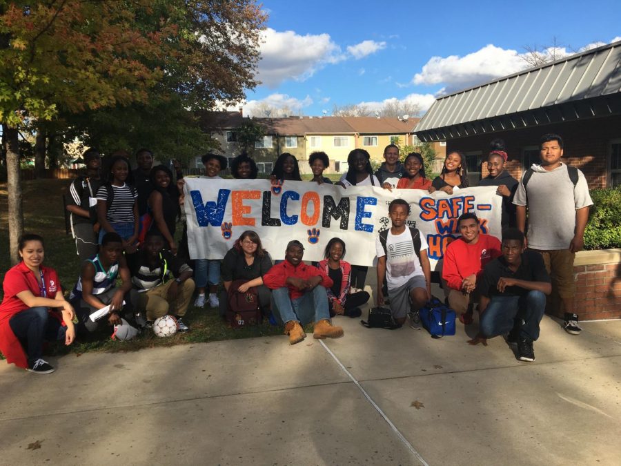 Los estudiantes de Watkins Mill High School dan la bienvenida a sus estudiantes de primaria con un cartel de Safe Walk Home