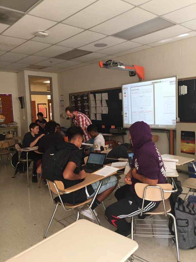 Los estudiantes de primer año de la clase de inglés Chris Smiths trabajan en una tarea