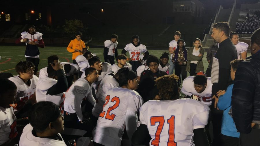 The team huddles as coach Michael Brown speaks post-win.