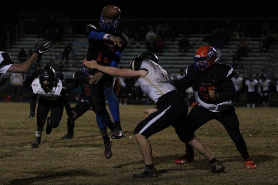 Sophomore Nehemai Cross throws the ball in midair as senior Anthony Santos moves to defend him.