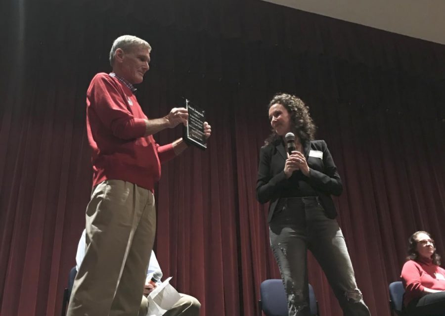 Watkins Mill alumn Jen Marchetti presents a plaque to retired teacher David Sampselle.