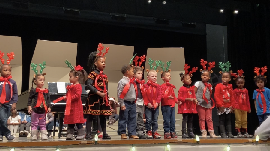 Niños en edad preescolar de desarrollo infantil cantando en su concierto de invierno.