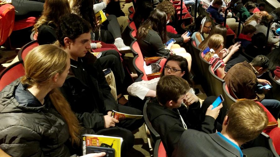 Students in the theater, eagerly waiting for the show to begin. 