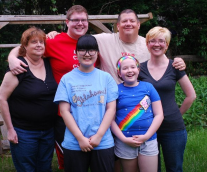 Math teacher Stephen Burrows (second from right) poses with his wife (far right), Erin Burrows, his daughter-in-law and son, Christine Hayward and Michael Burrows (left), his daughter Maddie Burrows (bottom right) and foreign exchange student Do Young Kim. The Burrows family has enjoyed hosting many foreign exchange students over the years.