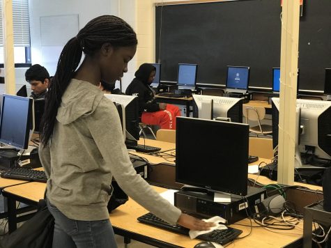 Freshman Melissa Osei-Bonsu cleans her computer keyboard with a Clorox wipe before using it in English class to protect herself from the coronavirus.