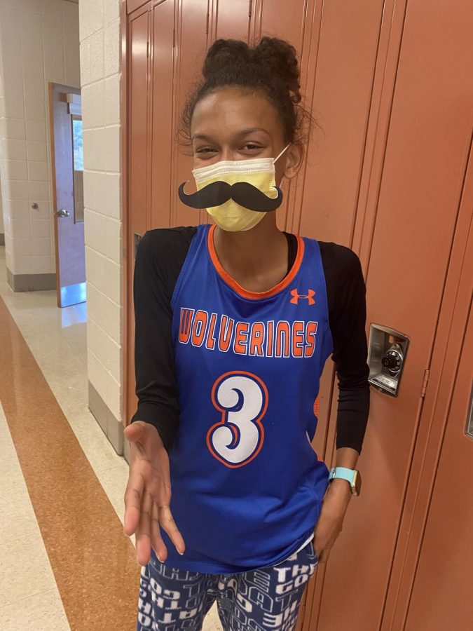 Junior Ella Rishell posing as a cheesy dad with a humorous moustache. 