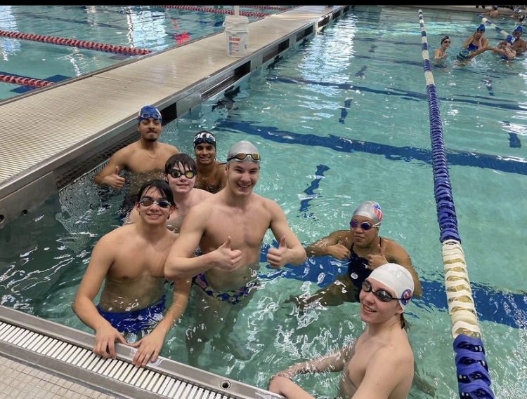 Our swimmers gathering together at the end of the pool right before a meet.